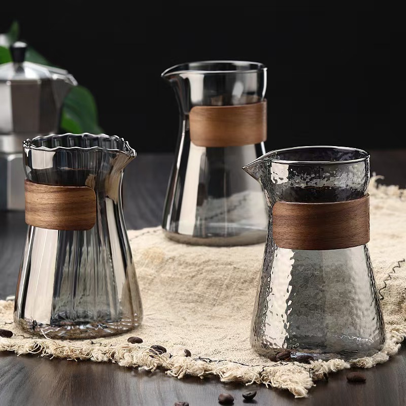 Produsen membagikan minuman panas yang dituangkan dengan tangan di atas teko kopi